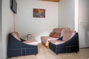 two chairs sitting in a room with a tv at Vikendica Luka in Čanj