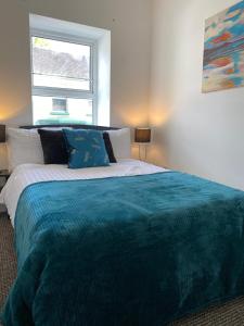 a bedroom with a large bed with a blue blanket at The White House in Derry Londonderry