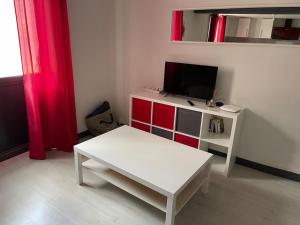 uma sala de estar com uma mesa branca e uma televisão em (B-1) Bourgueil Studio N•1 em Bourgueil