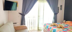 a bedroom with a bed and a large window at Mareverde Blue Studio Tenerife in Adeje