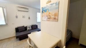 - un salon avec un canapé et une table dans l'établissement Appartamento Perla Marina, à Sottomarina