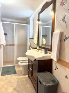 bagno con lavandino, servizi igienici e specchio di Dimora Saracena Forio a Ischia