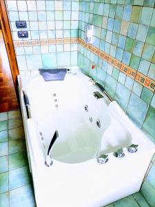 a bathtub in a bathroom with a tiled wall at La quercia di Massena in Lauria