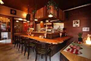 uma cozinha com um grande bar com cadeiras e um balcão em 帝塚山忍者屋敷 em Osaka