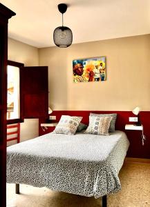 ein Schlafzimmer mit einem Bett und einem Wandgemälde in der Unterkunft CR "Calle Real" en la Sierra de Gredos in Villanueva de la Vera