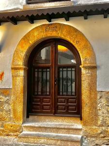 einen Eingang zu einem Gebäude mit einer Holztür in der Unterkunft CR "Calle Real" en la Sierra de Gredos in Villanueva de la Vera