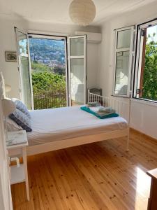 a bed in a room with large windows at Metropolis Villa in Vathi