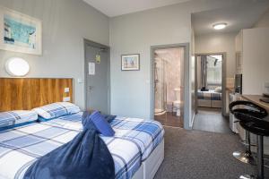 1 dormitorio con 1 cama con sábanas azules y blancas en Seaside Suites Superior Family Apartments, en Blackpool