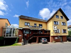 ein Gebäude mit einem davor geparkt in der Unterkunft Hotel-Barbarossa-Garni bei Hanau in Rodenbach