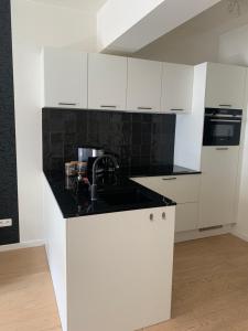 a kitchen with white cabinets and a sink at Coco's in Antwerp