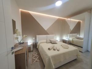 a bedroom with a large bed and a mirror at Lecci al Mare in San Vincenzo