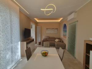 un soggiorno con tavolo bianco e divano di Lecci al Mare a San Vincenzo