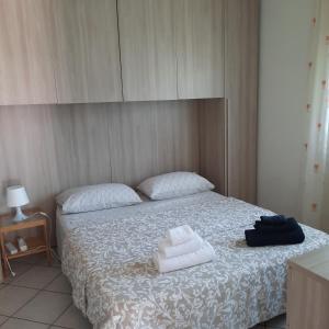Pugnanoにあるla casa di sandraのベッドルーム1室(ベッド1台、タオル2枚付)