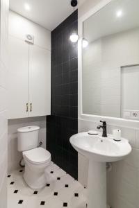 a bathroom with a toilet and a sink and a mirror at Apartment near the Opera Theater in Lviv