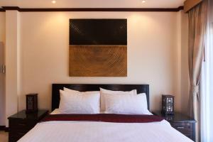 a bedroom with a bed with white sheets and a painting at Ananda Private Pool Villa, Ao Nang in Krabi town