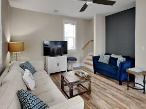 a living room with a white couch and a tv at Bungalows At Seagrove 149 - Three Little Birds Bungalow in Seagrove Beach