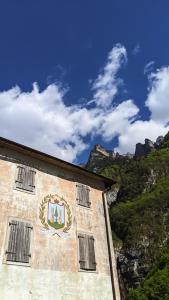 a building with a crest on the side of a mountain at Museo Ostello 