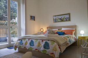 a bedroom with a bed and a large window at Neroli Mondello Palermo in Mondello