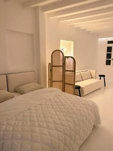 una camera bianca con un letto e un divano di Studio 77 a Mykonos Città