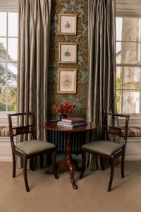 a table with two chairs and a table with books at Ballymaloe House Hotel in Ballycotton