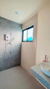 a bathroom with a shower and a sink and a window at Bests Village & Villa - Chalong Bay Phuket in Chalong