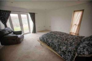 a bedroom with a bed and a couch and a window at Open plan house overlooking penshaw monument is in Sunderland