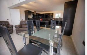 a dining room with a glass table and chairs at Open plan house overlooking penshaw monument is in Sunderland