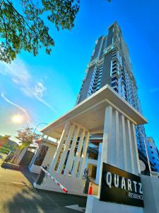 a apartment building with a sign in front of it at Quartz Paragon Suites By GGM in Melaka
