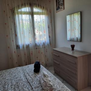 a bedroom with a bed and a dresser and a window at la casa di sandra in Pugnano
