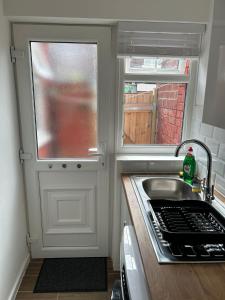 a small kitchen with a sink and a window at Charming Liverpool Home in Liverpool