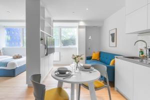 a kitchen and living room with a table and chairs at Livestay-Modern Apartments Next To Wembley Stadium in London