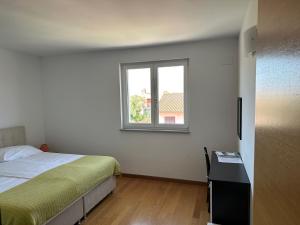 1 dormitorio con cama y ventana en Apartments Hanna, en Rovinj