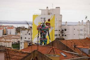 een groot schilderij aan de zijkant van een gebouw bij Olaias13 in Lissabon