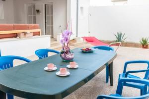 une table bleue avec des tasses et des soucoupes dessus dans l'établissement Ca Na Maria -Dorant-, à Son Serra de Marina