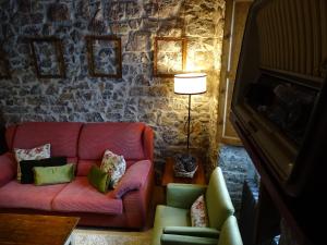 uma sala de estar com um sofá rosa e cadeiras em El Colladín em Llerices