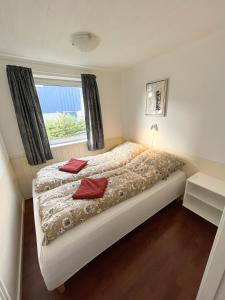 1 dormitorio con cama y ventana en Cosy apartment near beach, marina & city centre, en Tórshavn