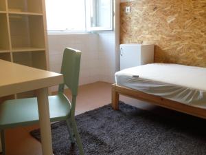 een kamer met een bureau en een bed en een tafel en stoel bij Olaias13 in Lissabon