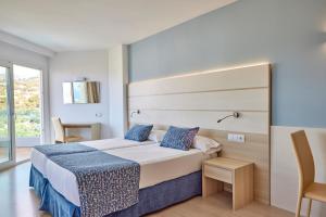ポータル・ヌースにあるTomir Portals Suites - Adults Onlyのベッドと大きな窓が備わるホテルルームです。