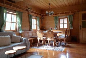 a living room with a table and chairs in a cabin at Ferienwohnungen Raczkowski in Birkfeld