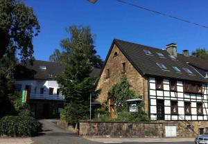 an old building with a black roof at Hotel Reesenhof in Witten