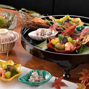 een tafel met een dienblad met eten op een tafel bij Ryokan Sumiya Kihoan in Kameoka