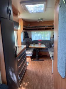 een woonkamer met een tafel in een camper bij Caravan op Camping t Kopske in Den Hout in Den Hout