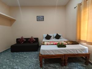 チクマガルールにあるNidagodu Homestayのベッドとソファのある寝室