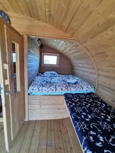 a bed in the inside of a wooden cabin at Manija saare süda - Manija island in Pärnu