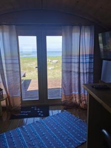 a bedroom with a view of the ocean from the door at Manija saare süda - Manija island in Pärnu