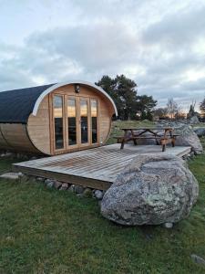 a small cabin with a wooden deck and a picnic table at Manija saare süda - Manija island in Pärnu