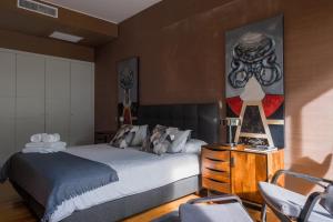 um quarto com uma cama e um quadro na parede em House of Joy em Estoril