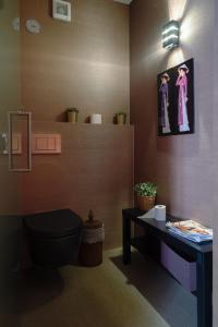uma casa de banho com WC e uma fotografia na parede em House of Joy em Estoril