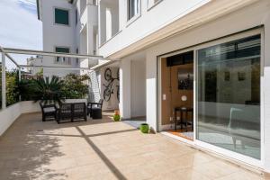 a patio with a glass door and a table and chairs at House of Joy in Estoril