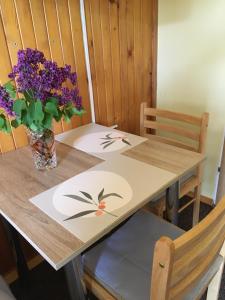 una mesa de madera con un jarrón de flores. en Willa Ewa, en Busko-Zdrój